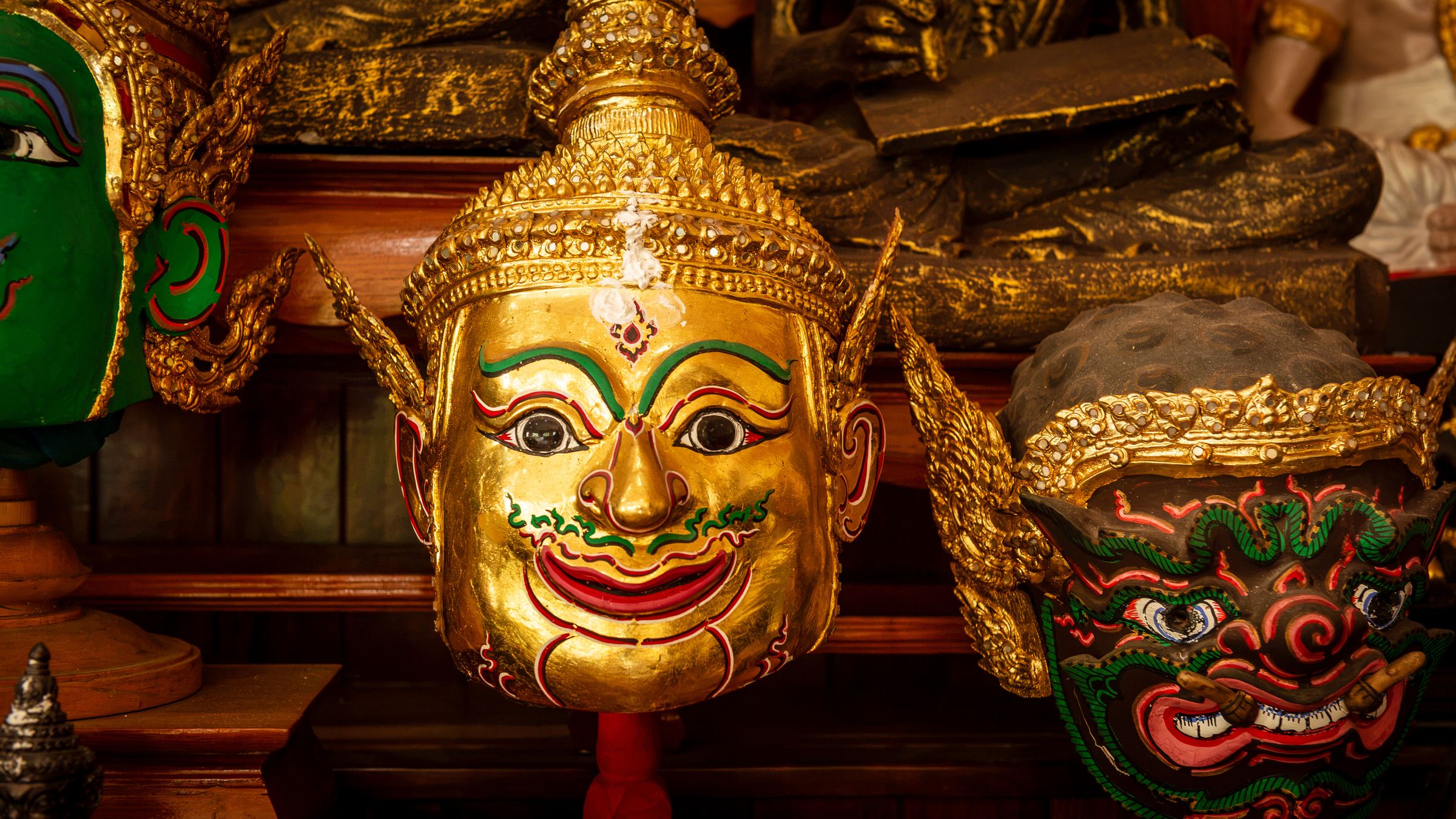 Gilded masks on the samnak altar