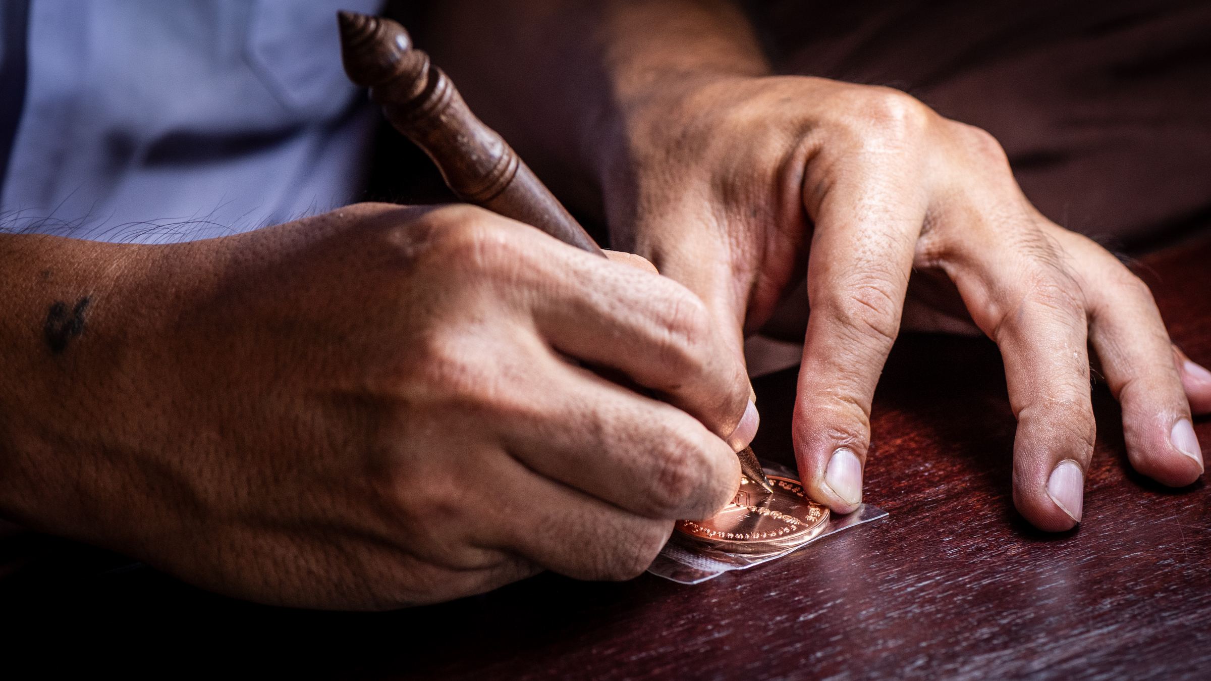 Ajarn Thueng inscribing an amulet by hand
