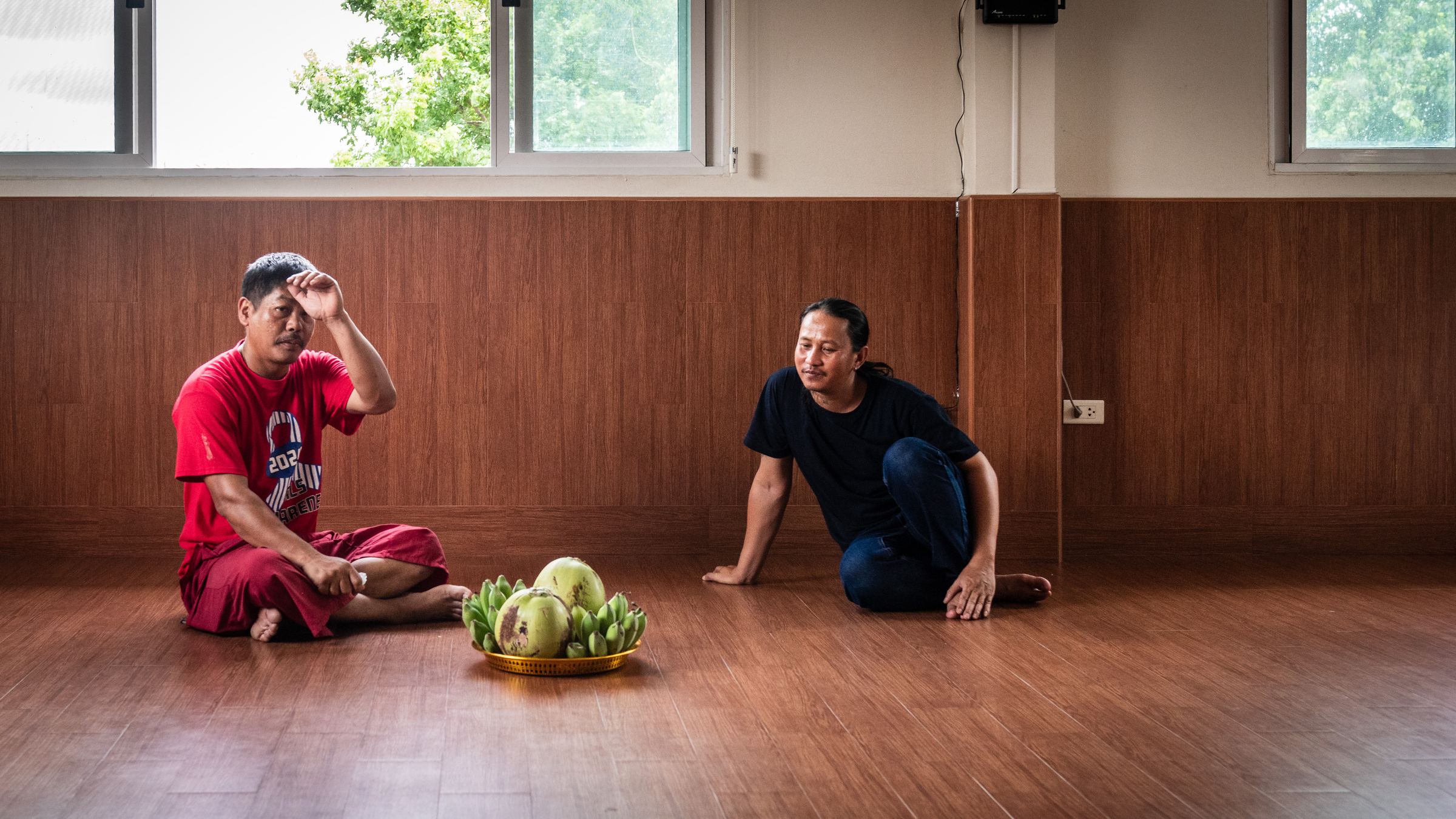 Two of Ajarn Thueng's disciples beside a tray of ritual offerings