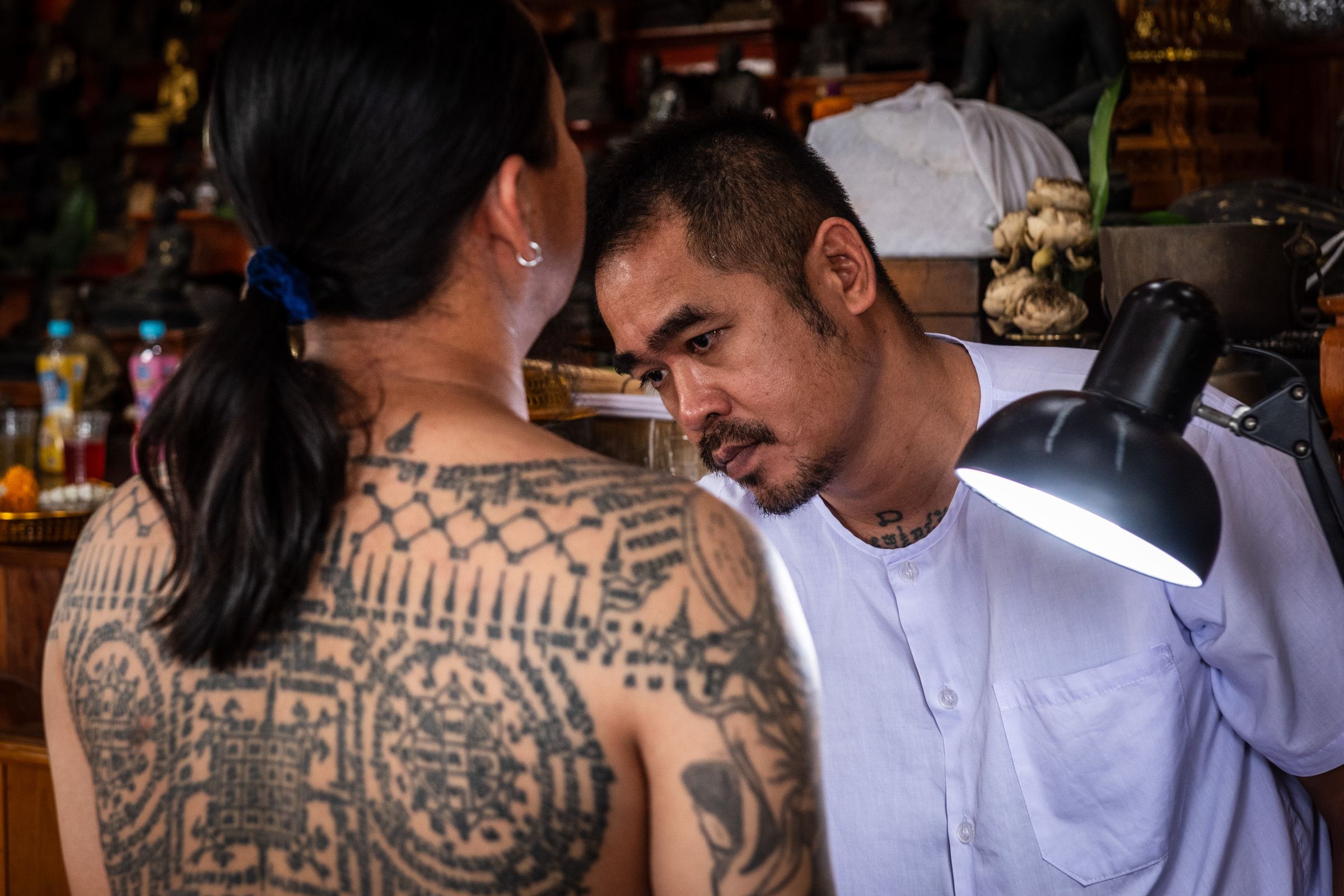 The Ajarn examining a tattooed back